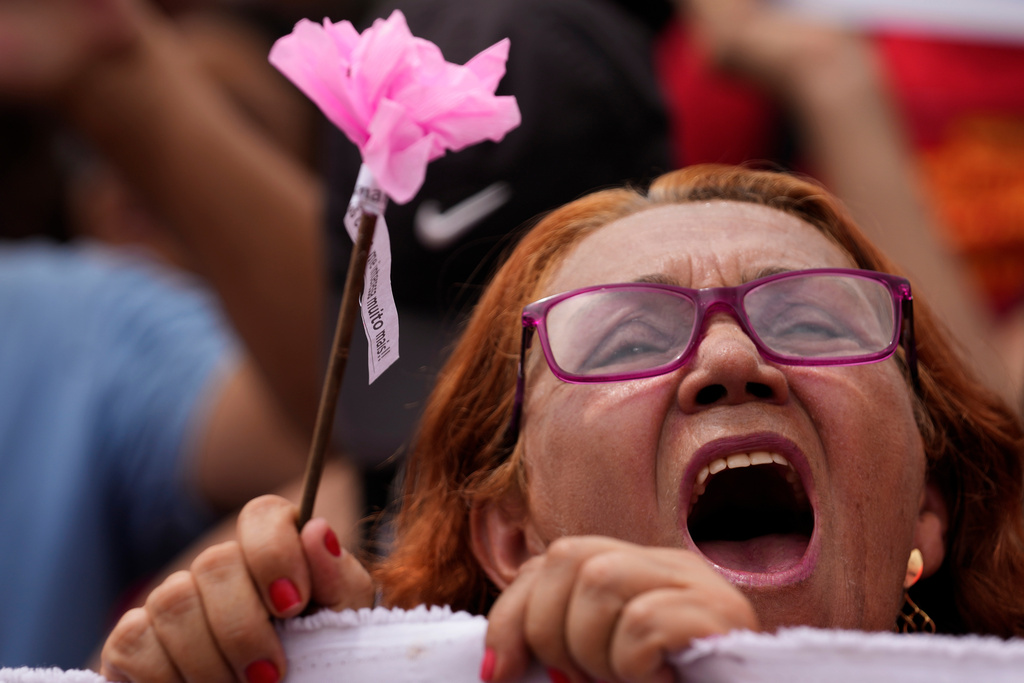 A demonstrator shouts "No amnesty" in Portuguese during a protest against a bill in that looks to reduce former President Jair Bolsonaro's prison time, in Brasilia, Brazil, Sunday, Dec. 14, 2025. (AP Photo/Eraldo Peres)