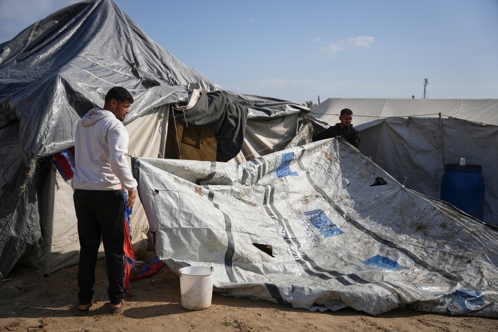 Muhannad Abu Muharib, 27, reinforces his tent after it was damaged by a storm at a temporary camp on the beach in Deir al-Balah, in the central Gaza Strip, Saturday, Nov. 15, 2025. (AP Photo/Abdel Kareem Hana)