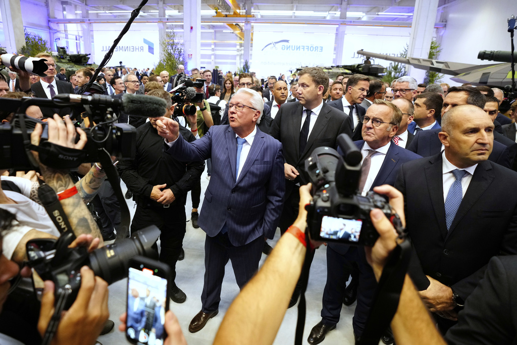 Rheinmetall CEO Armin Papperger, center, gestures besides NATO Secretary General Mark Rutte, background right, German Defense Minister Boris Pistorius, foreground right, and German Vice Chancellor Lars Klingbeil, background center, while the inauguration of the newly built artillery ammunition plant by German arms manufacturer Rheinmetall in Unterluess, Germany, Wednesday, Aug. 27, 2025. (AP Photo/Markus Schreiber)