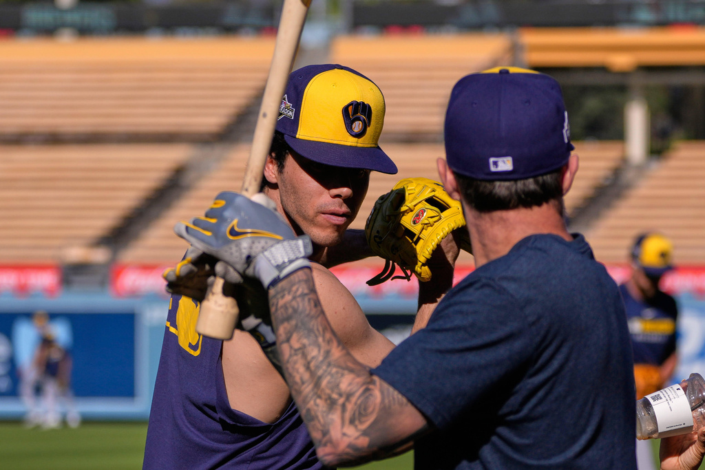 Milwaukee Brewers' Christian Yelich, left, and Brice Turang warm up during practice ahead of Game 3 of baseball's National League Championship Series against the Los Angeles Dodgers, Wednesday, Oct. 15, 2025, in Los Angeles. (AP Photo/Mark J. Terrill)