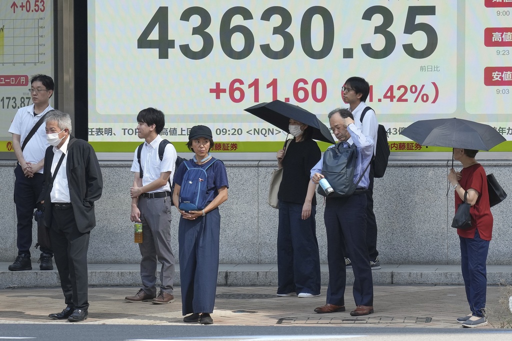 People stand in front of an electronic stock board showing Japan's Nikkei index at a securities firm Monday, Sept. 8, 2025, in Tokyo. (AP Photo/Eugene Hoshiko)