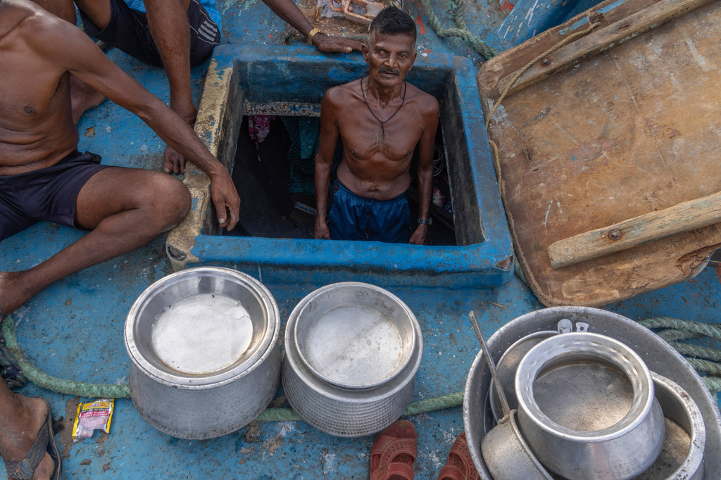 A fisherman stands inside his boat anchored due the price high at Sassoon Dock in Mumbai, India, Tuesday, April 7, 2026. (AP Photo/Rafiq Maqbool)