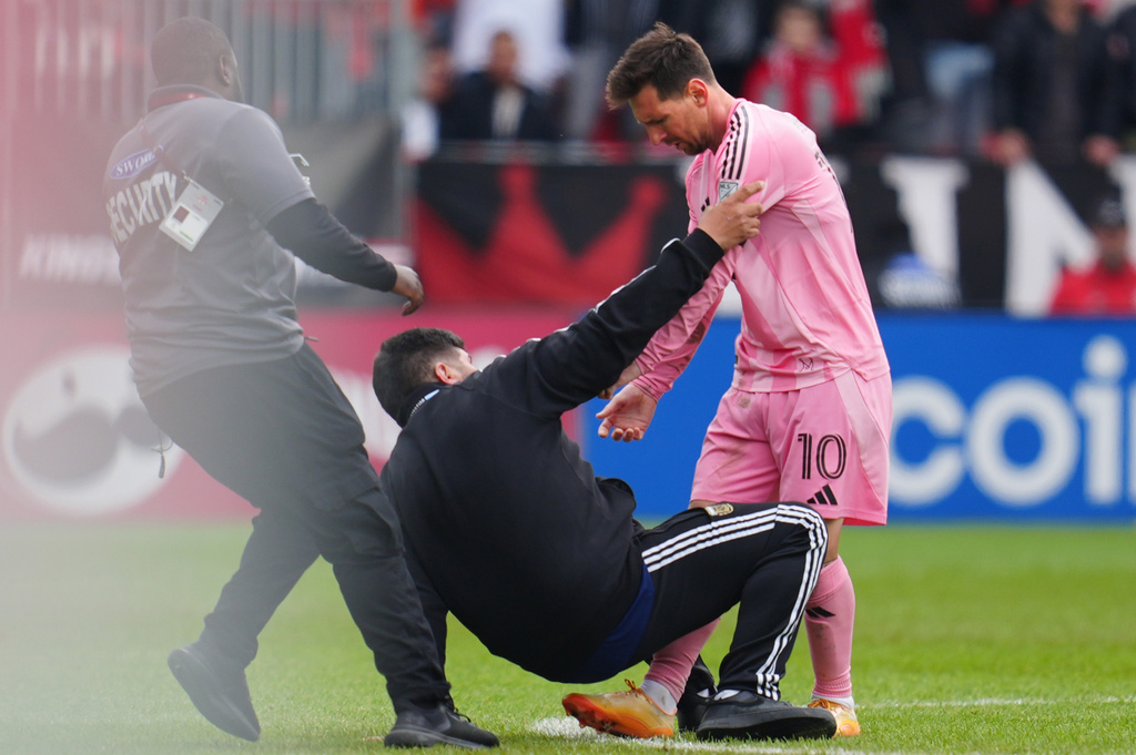 Security arrives to take a fan off the field after he ran on to meet Inter Miami CF midfielder Lionel Messi (10) during second half MLS soccer against Toronto FC, in Toronto on Saturday, May 9, 2026. (Frank Gunn/The Canadian Press via AP)