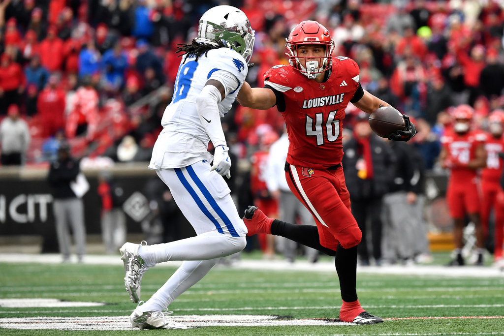 Louisville running back Braxton Jennings (46) stiff arms Kentucky defensive back Cam Dooley (18) during the second half of an NCAA college football game in Louisville, Ky., Saturday, Nov. 29, 2025. (AP Photo/Timothy D. Easley)