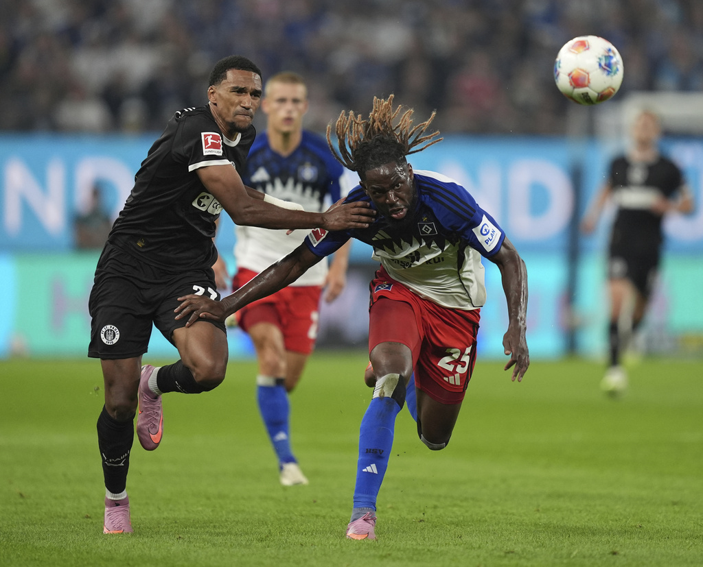 FC St. Pauli's Andreas Hountondji, left, and Hamburger SV's Jordan Torunarigha chase after for the ball during the German Bundesliga soccer match between Hamburger SV and FC St. Pauli at Volksparkstadion in Hamburg, Germany, Friday, Aug. 29, 2025. (Marcus Brandt/dpa via AP)