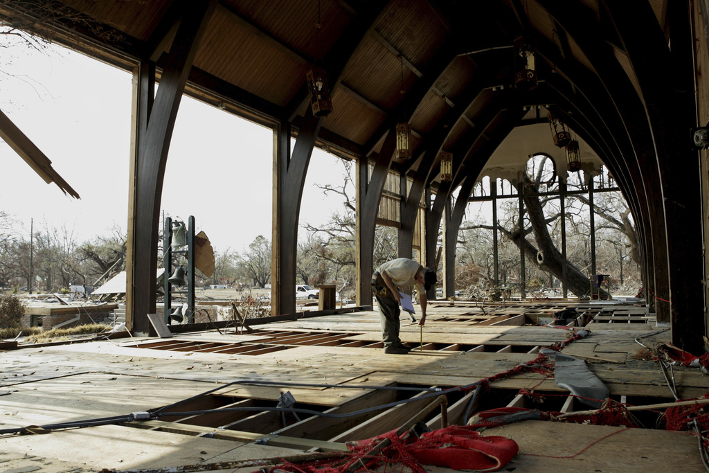 FILE - Structural engineer, Carl Edwards, working for Church Mutual Insurance Company, measures the floor in the gutted Trinity Episcopal Church in Pass Christian, Miss., Sept. 17, 2005. (AP Photo/Steve Helber, File)