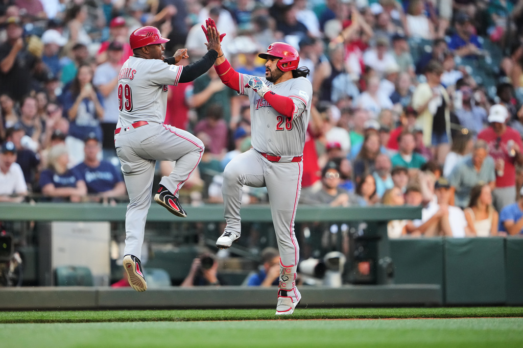 Cincinnati Reds' Eugenio Suárez, right, celebrates his solo home run with third base coach Willie Harris, left, as he runs the bases during the fourth inning of a baseball game against the Seattle Mariners, Tuesday, July 21, 2026, in Seattle. (AP Photo/Lindsey Wasson)