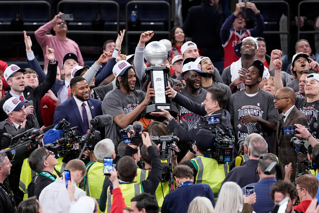 St. John's head coach Rick Pitino hands a tournament trophy to St. John's forward Zuby Ejiofor after an NCAA college basketball game against UConn in the championship of the Big East tournament, Saturday, March 14, 2026, in New York. (AP Photo/Yuki Iwamura)