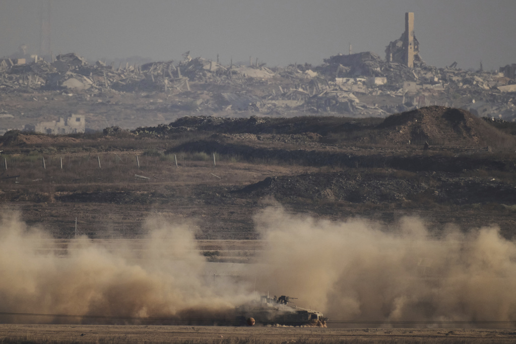 An Israeli armoured personnel carrier (APC) moves through the Israeli-Gaza border, as seen from southern Israel, Monday, Aug. 25, 2025. (AP Photo/Leo Correa)