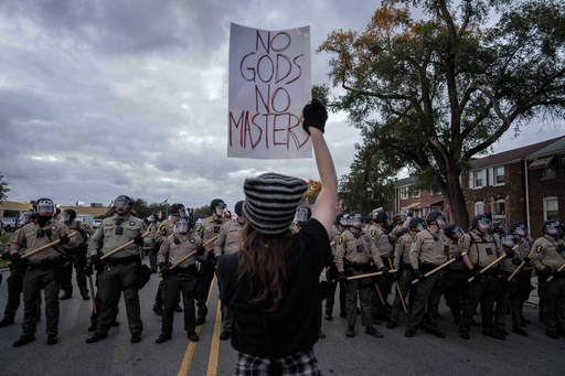 A demonstrator holds a sign as Illinois State Police move the crowd back after declaring an unlawful assembly outside the U.S. Immigration and Customs Enforcement facility in Broadview, Ill., Saturday, Oct. 11, 2025. (AP Photo/Adam Gray) A demonstrator holds a sign as Illinois State Police move the crowd back after declaring an unlawful assembly outside the U.S. Immigration and Customs Enforcement facility in Broadview, Ill., Saturday, Oct. 11, 2025. (AP Photo/Adam Gray)