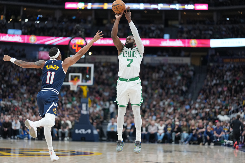 Boston Celtics guard Jaylen Brown, right, shoots for a basket over Denver Nuggets guard Bruce Brown in the first half of an NBA basketball game Wednesday, Feb. 25, 2026, in Denver. (AP Photo/David Zalubowski)