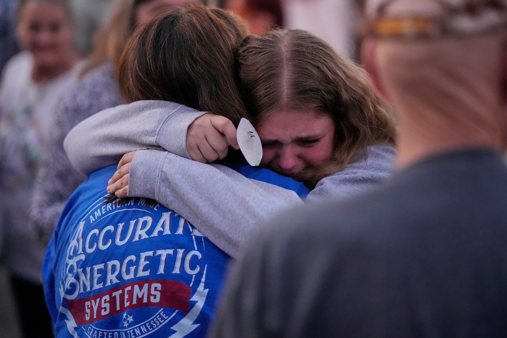 People console each other during a candlelight vigil honoring the victims of a blast at an explosives plant, Accurate Energetic Systems, Sunday, Oct. 12, 2025, in Waverly, Tenn. (AP Photo/George Walker IV)