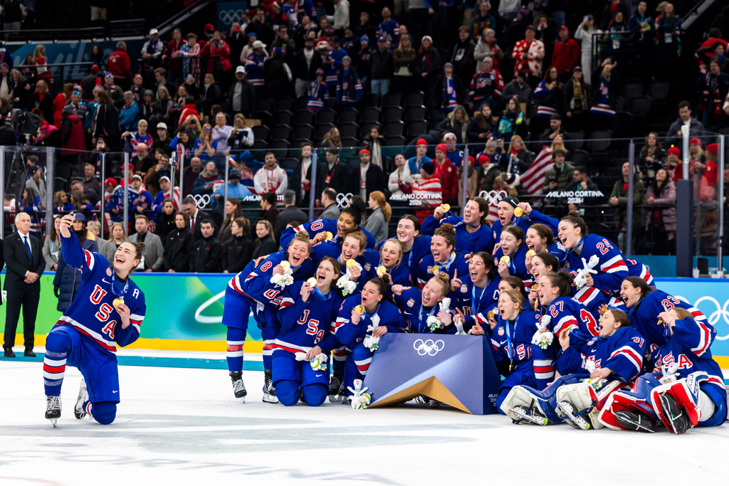 United States' Megan Keller, left, who scored the game winning goal in overtime, takes a selfie with teammates as they celebrate after defeating Canada in the women's ice hockey gold medal game at the 2026 Winter Olympics in Milan, Italy, Thursday, Feb. 19, 2026. (Salvatore Di Nolfi/Keystone via AP)