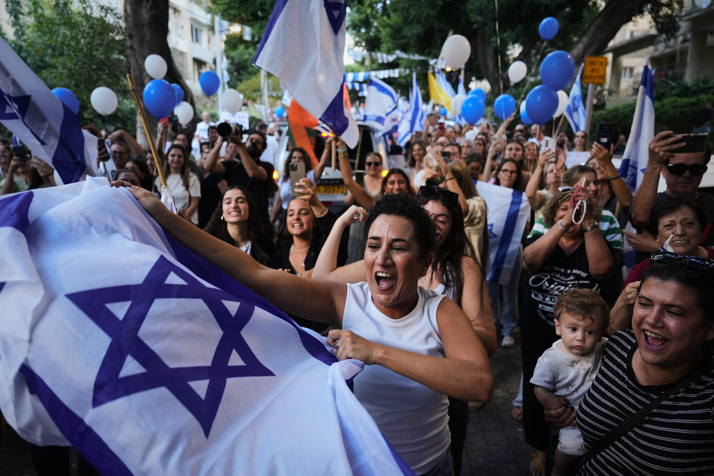 People celebrate as freed Israeli hostage Evyatar David, recently released from Hamas captivity in Gaza, returns home from the hospital to Kfar Saba, Israel, Sunday, Oct. 26, 2025. (AP Photo/Ariel Schalit)