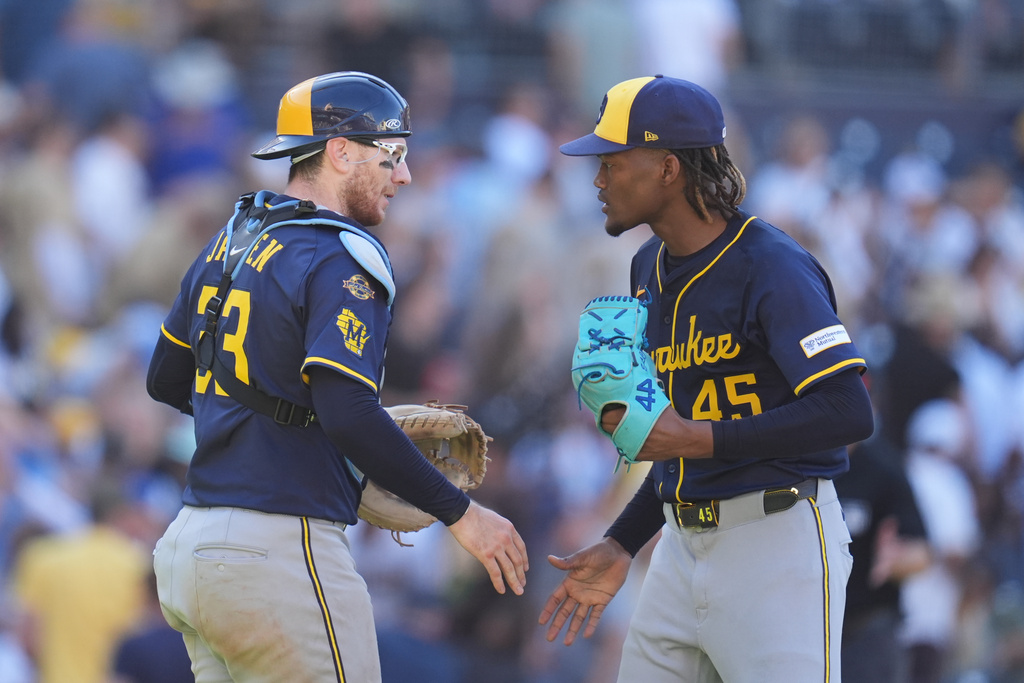 Milwaukee Brewers relief pitcher Abner Uribe, right, celebrates with teammate catcher Danny Jansen after the Brewers defeated the San Diego Padres 3-1 in a baseball game Wednesday, Sept. 24, 2025, in San Diego. (AP Photo/Gregory Bull)
