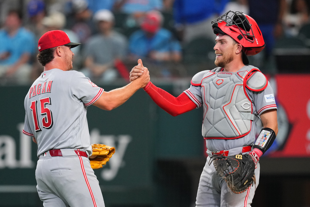 Cincinnati Reds pitcher Emilio Pagán, left, and catcher Tyler Stephenson react after their team defeated the Texas Rangers 5-3 during the Rangers' home-opener baseball game Friday, April 3, 2026, in Arlington, Texas. (AP Photo/Julio Cortez)