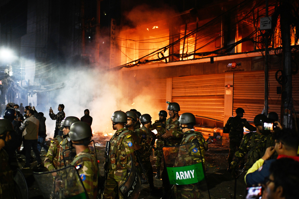 Bangladesh army stands guard at the premises of the Prothom Alo daily newspaper after angry protesters set it on fire after news reached the country from Singapore of the death of a prominent activist Sharif Osman Hadi, in Dhaka, Bangladesh, Friday, Dec. 19, 2025. (AP Photo/Mahmud Hossain Opu)