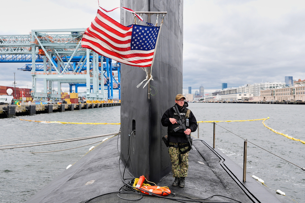 A sailor stands guard next to the sail of the USS Massachusetts, the Navy's newest nuclear-powered attack submarine, Friday, March 27, 2026, in Boston. (AP Photo/Robert F. Bukaty)