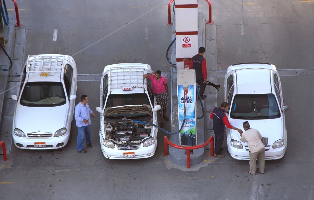 FILE - Taxi drivers chat as they refuel their vehicles at a gas station in Cairo, Egypt, on June 29, 2017. (AP Photo/Amr Nabil, File)