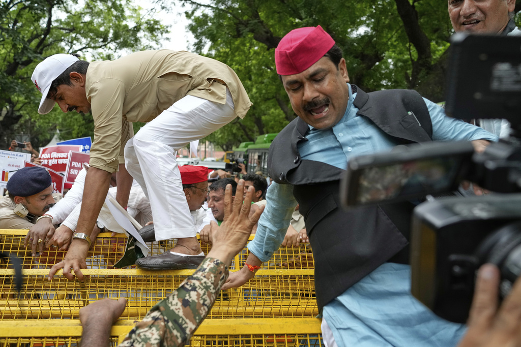 Lawmakers from various opposition jump over a police barricade during a protest calling for the rollback of a controversial revision of the voter list in one of the country’s poorest states where key elections are scheduled in November, in New Delhi, India, Monday, Aug. 11, 2025. (AP Photo/Manish Swarup)