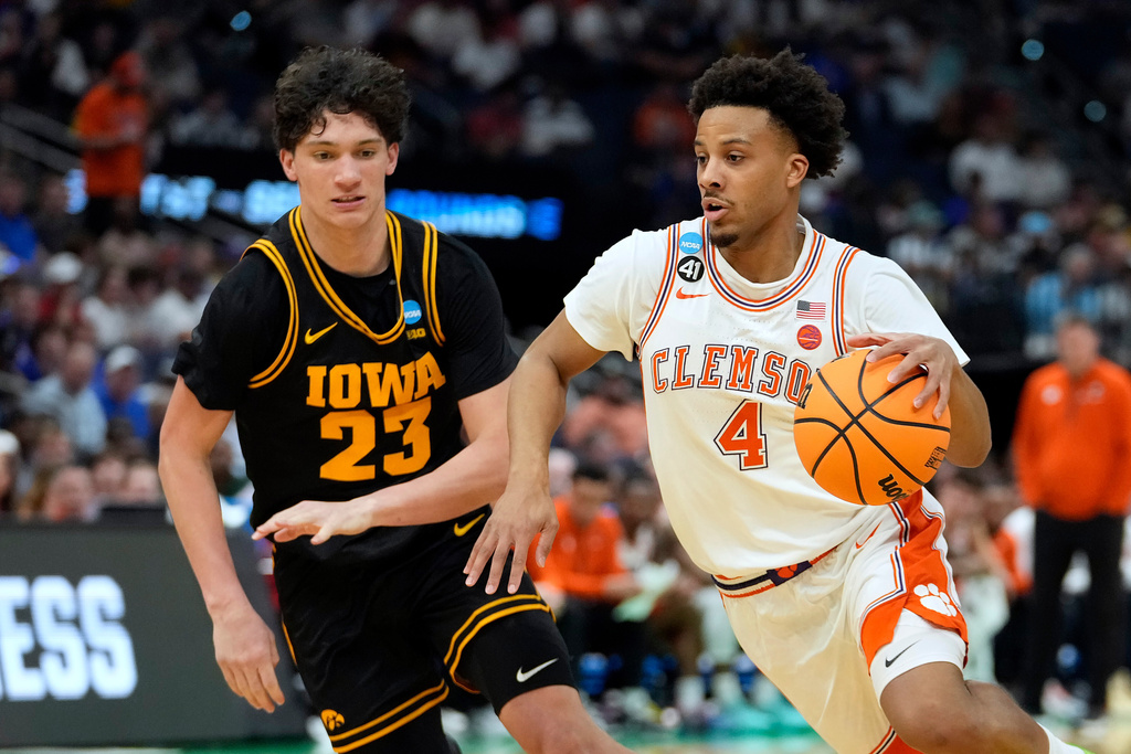Clemson guard Efrem Johnson (4) drives around Iowa guard Isaia Howard (23) during the first half in the first round of the NCAA college basketball tournament Friday, March 20, 2026, in Tampa, Fla. (AP Photo/Chris O'Meara)