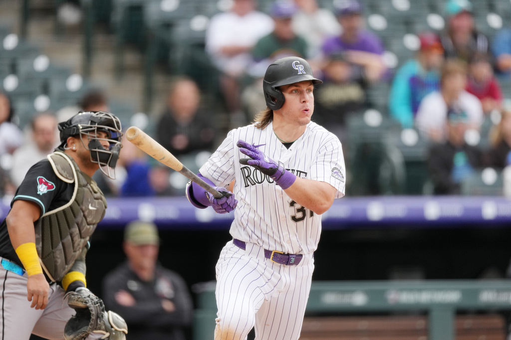 Colorado Rockies' Jake McCarthy, right, breaks from the batter's box after connecting for an RBI single off Arizona Diamondbacks relief pitcher Brandon Pfaadt in the eighth inning of a baseball game Sunday, May 17, 2026, in Denver. (AP Photo/David Zalubowski)