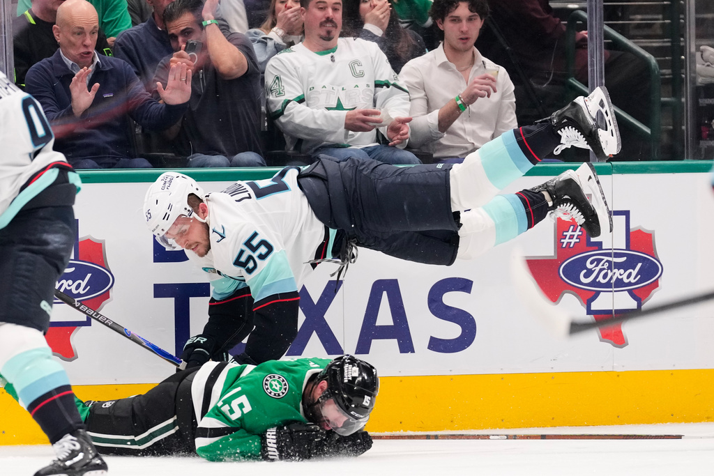 Seattle Kraken defenseman Ryan Lindgren (55) and Dallas Stars' Colin Blackwell (15) collide as they compete in the first period of an NHL hockey game in Dallas, Wednesday, Feb. 25, 2026. (AP Photo/Tony Gutierrez)