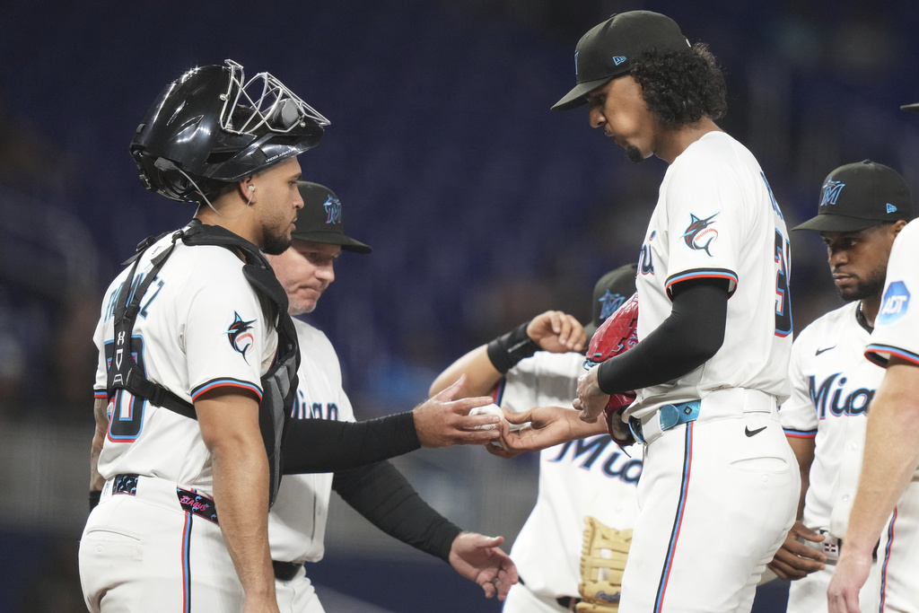 Miami Marlins starting pitcher Eury Perez, right, hands the ball to manager Clayton McCullough, left, after being relieved during the fifth inning of a baseball game against the St. Louis Cardinals, Monday, Aug. 18, 2025, in Miami. (AP Photo/Lynne Sladky)
