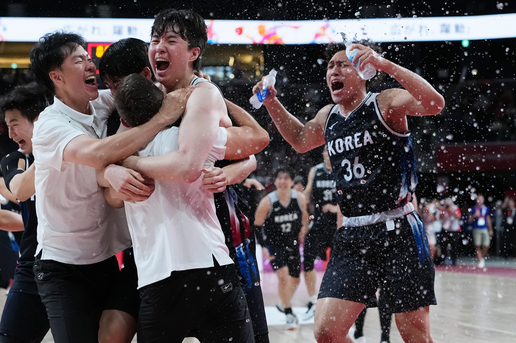 South Korean players and support staff celebrate after winning the men's basketball final against Japan at the Asian Games in Nagoya, Japan, Sunday, Sept. 20, 2026. (AP Photo/Aaron Favila)