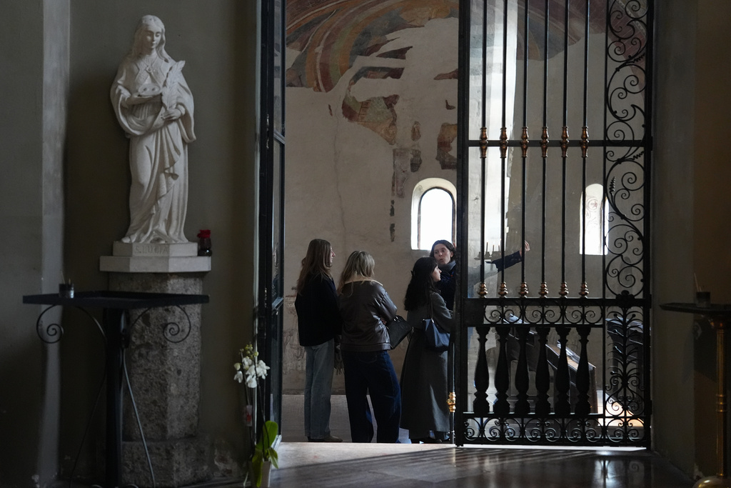 Giovanna Giuditta Mazza, right, leads a small group of visitors inside the Basilica of San Lorenzo Maggiore as part of the “La Via della Bellezza,” or “The Path of Beauty,” initiative in Milan, Italy, Wednesday, Feb. 18, 2026. Volunteers with the archdiocese’s youth ministry office offer free visits highlighting the artistic and spiritual heritage of the churches. (AP Photo/María Teresa Hernández)