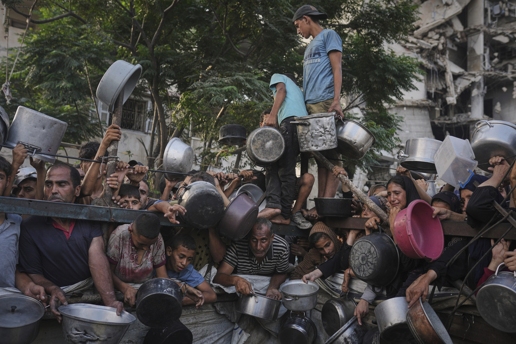 FILE - Palestinians struggle to get donated food at a community kitchen in Gaza City, northern Gaza Strip, July 14, 2025. (AP Photo/Jehad Alshrafi, File)