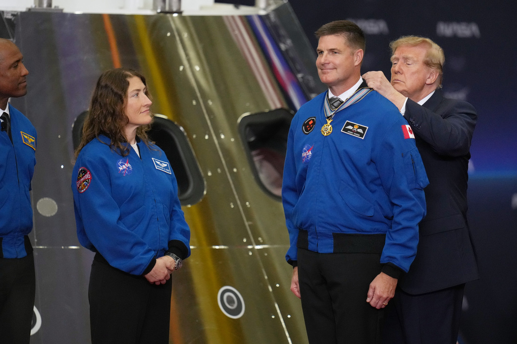 President Donald Trump participates in a Congressional Space Medal of Honor ceremony at NASA's Johnson Space Center, Friday, Aug. 28, 2026, in Houston, and puts a medal on Artemis II Astronaut and Mission Specialist, Jeremy Hansen. (AP Photo/Karen Warren)