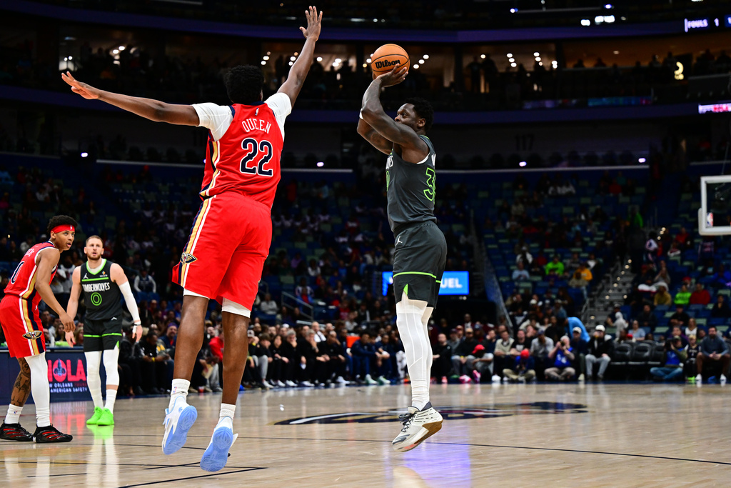 Minnesota Timberwolves forward/center Julius Randle, right, goes up to shoot against New Orleans Pelicans center Derik Queen (22) in the first half of an NBA basketball game in New Orleans, Thursday, Dec. 4, 2025. (AP Photo/Ella Hall)