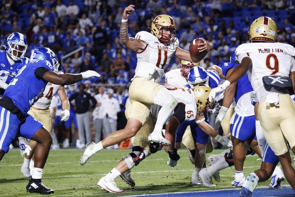 Elon's Landen Clark (11) jumps into the end zone for a touchdown against Duke during an NCAA college football game in Durham, N.C., Thursday, Aug. 28, 2025. (AP Photo/Ben McKeown)