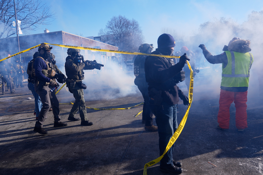 Federal immigration officers deploy tear gas at protesters after a shooting Saturday, Jan. 24, 2026, in Minneapolis. (AP Photo/Abbie Parr)