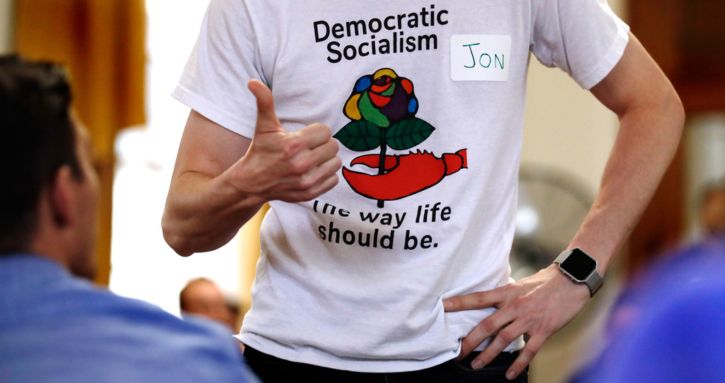 FILE - Jon Torsch wears a T-shirt promoting democratic socialism during a gathering of the Southern Maine Democratic Socialists of America at City Hall in Portland, Maine, July 16, 2018. (AP Photo/Charles Krupa)
