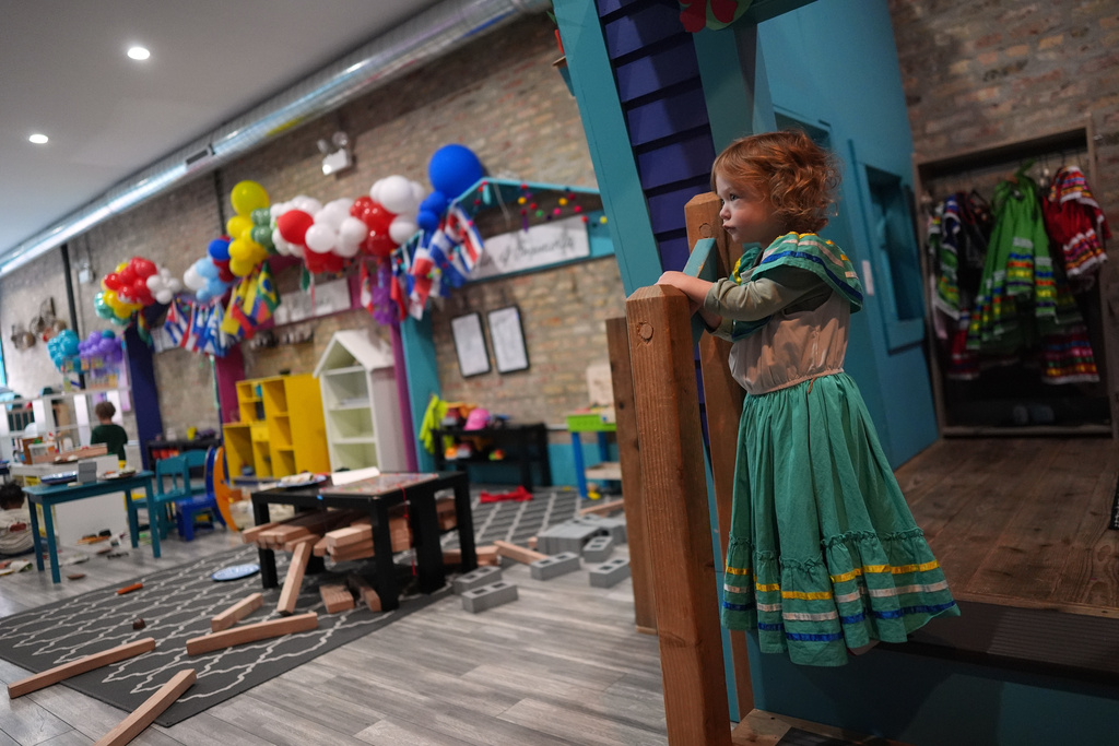 Two-year-old Ellie Bashinski wears a dress-up outfit as she plays inside Luna y Cielo Play Cafe, where kids learn and practice the Spanish language as they play, in Chicago's Logan Square neighborhood, Wednesday, Oct. 15, 2025. (AP Photo/Rebecca Blackwell)