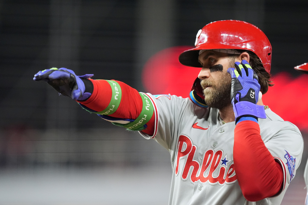 Philadelphia Phillies' Bryce Harper celebrates on first base after singling on a line drive during the eighth inning of a baseball game against the Miami Marlins, Monday, May 4, 2026, in Miami. (AP Photo/Rebecca Blackwell)
