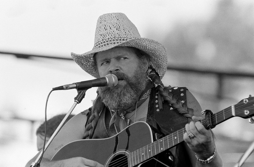 FILE - David Allan Coe, sporting Willie Nelson braids, performs at the Willie Nelson July 4th Picnic, on July 4, 1983 at Atlanta International Raceway in Hampton, Ga. (AP Photo/Rudolph Faircloth, File)