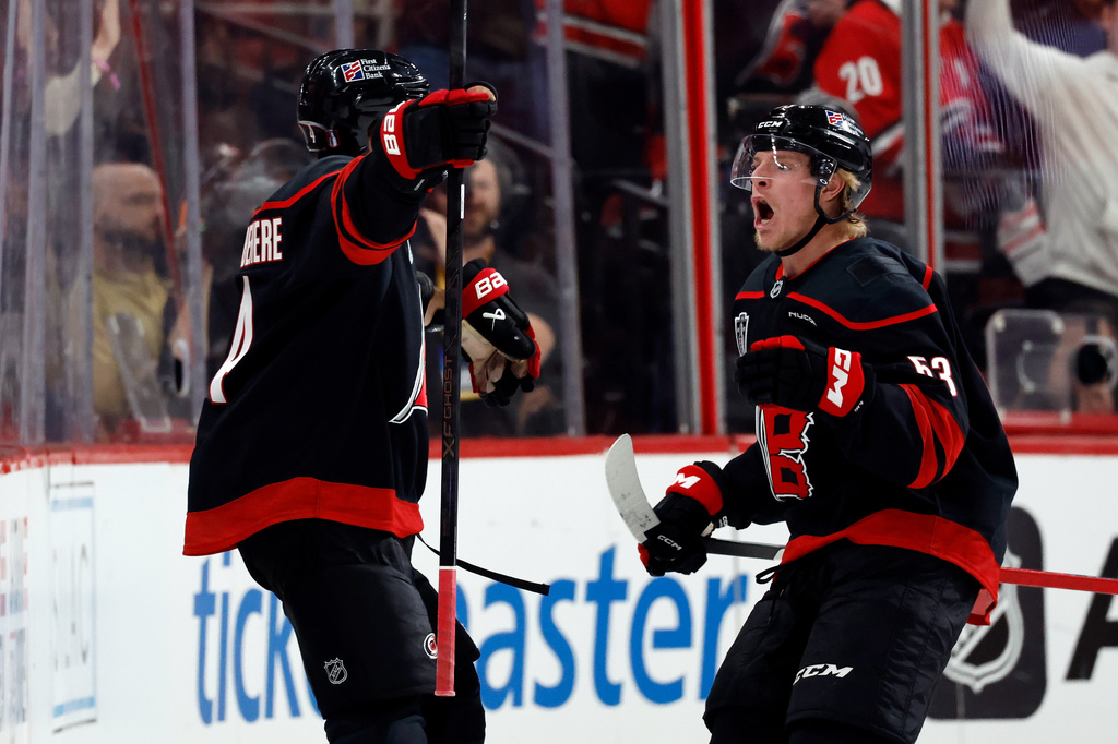 Carolina Hurricanes' Shayne Gostisbehere (4) celebrates his goal with Carolina Hurricanes' Jackson Blake (53) during the third period in Game 1 of the NHL hockey Stanley Cup Final series against the Vegas Golden Knights in Raleigh, N.C., Tuesday, June 2, 2026. (AP Photo/Karl DeBlaker)