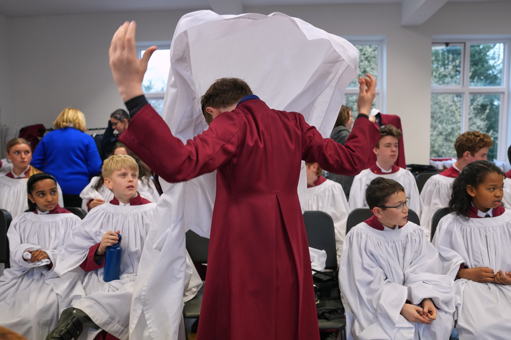 Britain Choral Music Choristers put on their garments for Evensong at Rochester Cathedral in Rochester, England, Friday, March 27, 2026. (AP Photo/Kin Cheung)