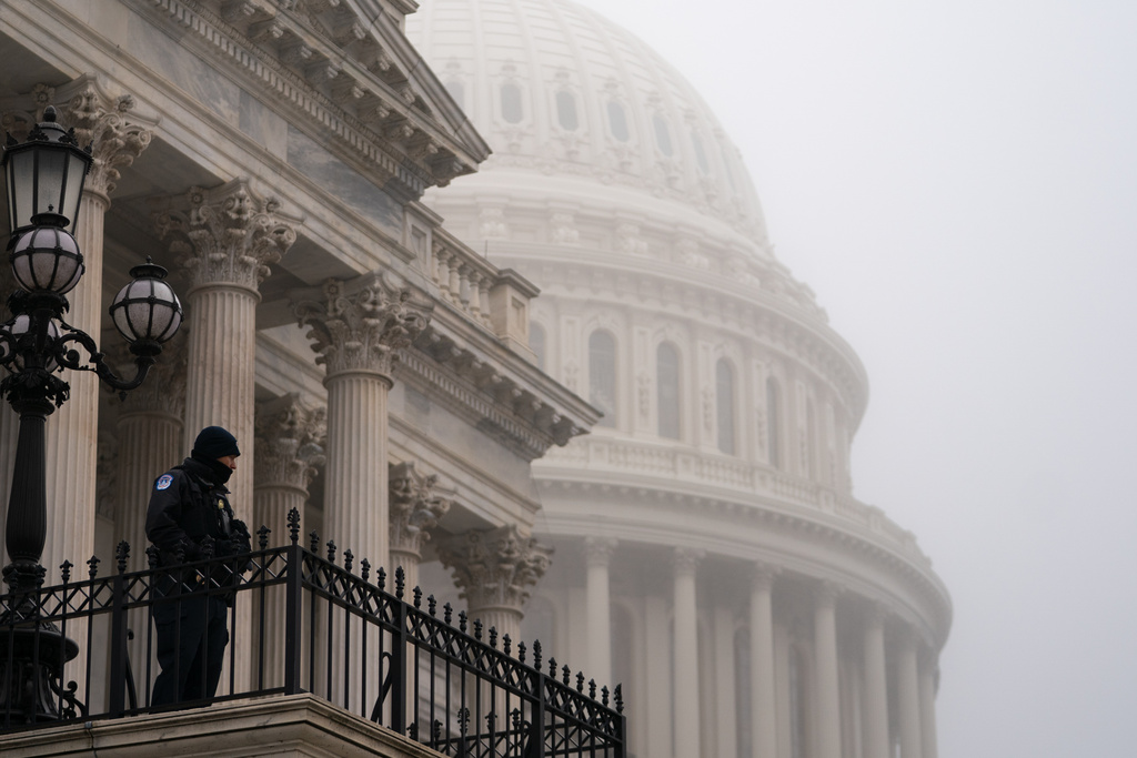 A Capitol Police Officer watches from his post on a foggy morning in front of the Capitol dome, Thursday, March 5, 2026, in Washington. (AP Photo/Allison Robbert)