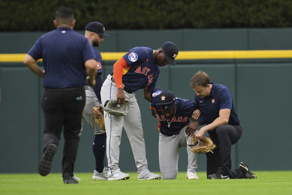 Houston Astros center fielder Taylor Trammell, second from right, is helped after being injured attempting to catch a Detroit Tigers' Dillon Dingler fly ball in the first inning during a baseball game Wednesday, Aug. 20, 2025, in Detroit. (AP Photo/Paul Sancya)