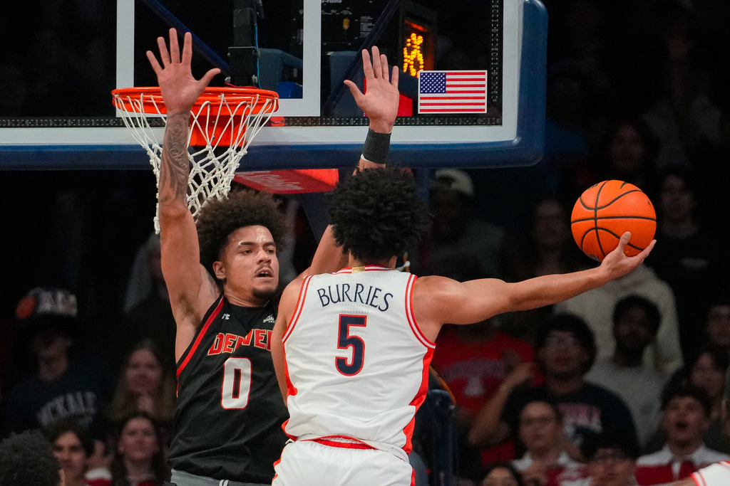 Arizona Wildcats guard Brayden Burries (5) attempts to shoot over Denver Pioneers forward Jeremiah Burke (0) during the first half of an NCAA college basketball game, Monday, Nov. 24, 2025, in Tucson, Ariz. (AP Photo/Darryl Webb)