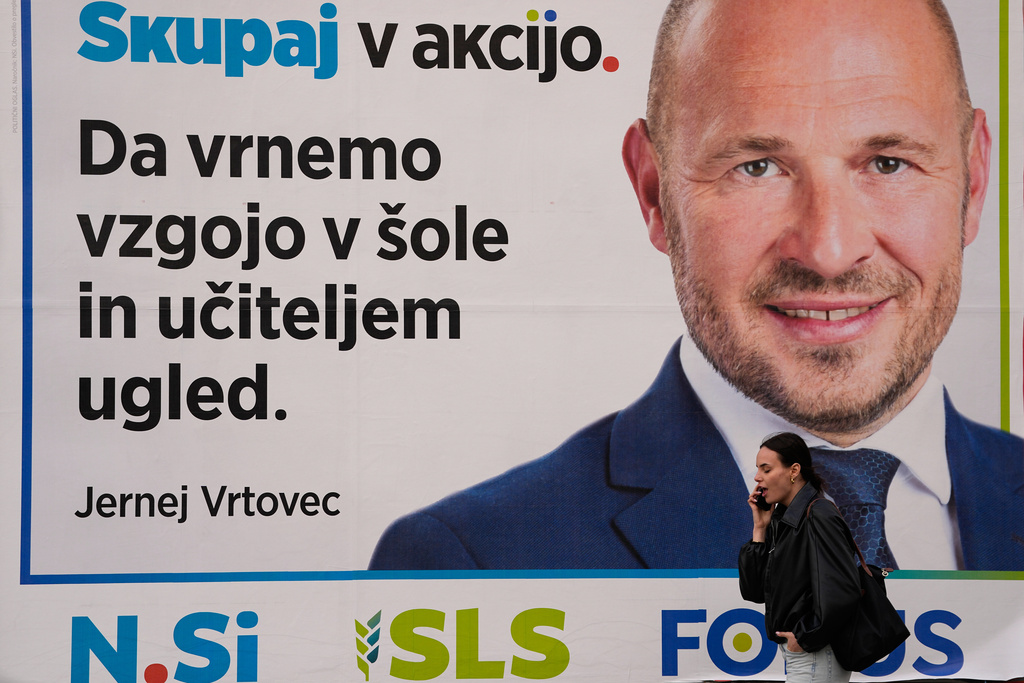 A pedestrian walks past a electoral poster in Ljubljana, Slovenia, Wednesday, March 18, 2026. (AP Photo/Darko Bandic)