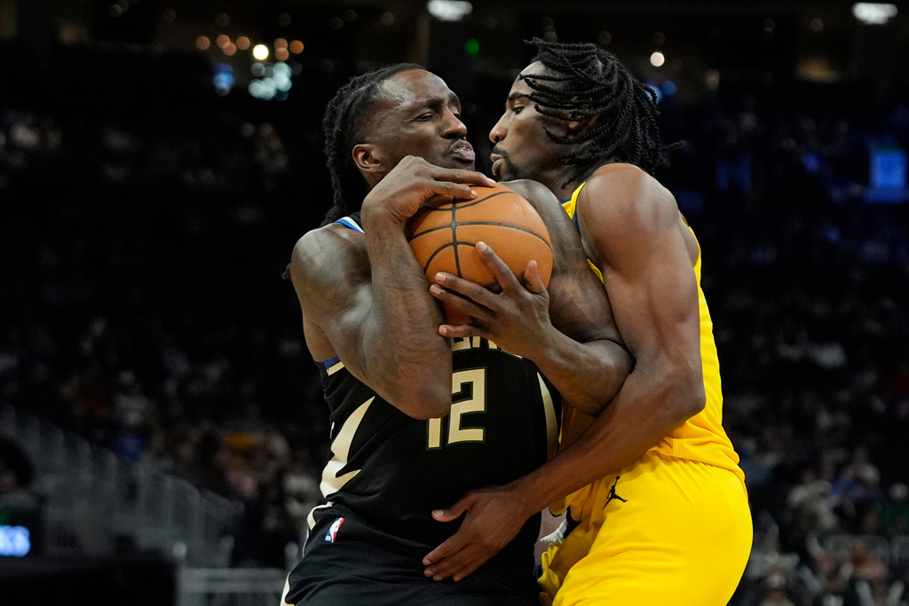 Milwaukee Bucks' Taurean Prince (12) drives to the basket against Indiana Pacers' Aaron Nesmith, right, during the second half of an NBA basketball game, Sunday, March 15, 2026, in Milwaukee. (AP Photo/Aaron Gash)