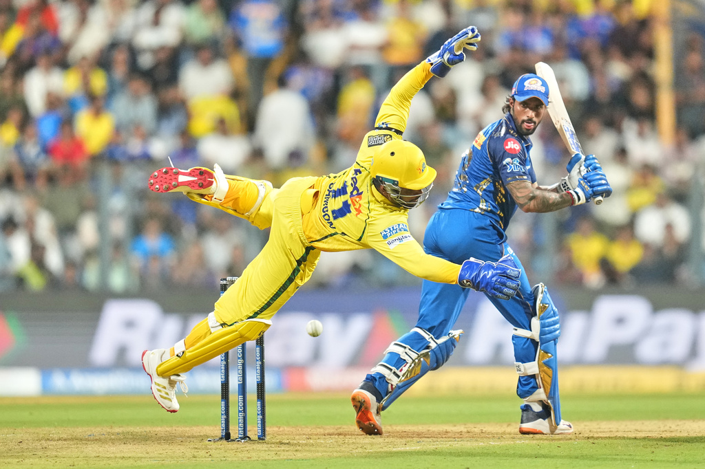 Chennai Super Kings' Sanju Samson dives to field the ball as Mumbai Indians' Tilak Varma looks back after playing a shot during the Indian Premier League cricket match between Mumbai Indians and Chennai Super Kings in Mumbai, India, Thursday, April 23, 2026.(AP Photo/ Rafiq Maqbool)
