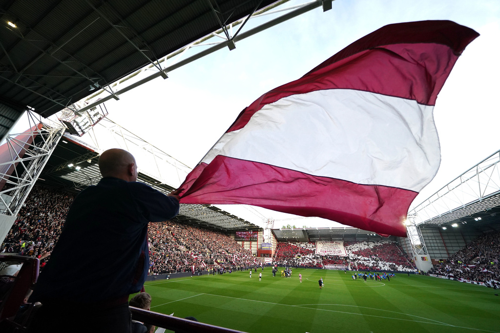 A Heart of Midlothian fan waves a large flag ahead the Scottish Premiership soccer match between Heart of Midlothian and Falkirk, Wednesday, May 13, 2026, in Edinburgh, Scotland. (Andrew Milligan/PA via AP)