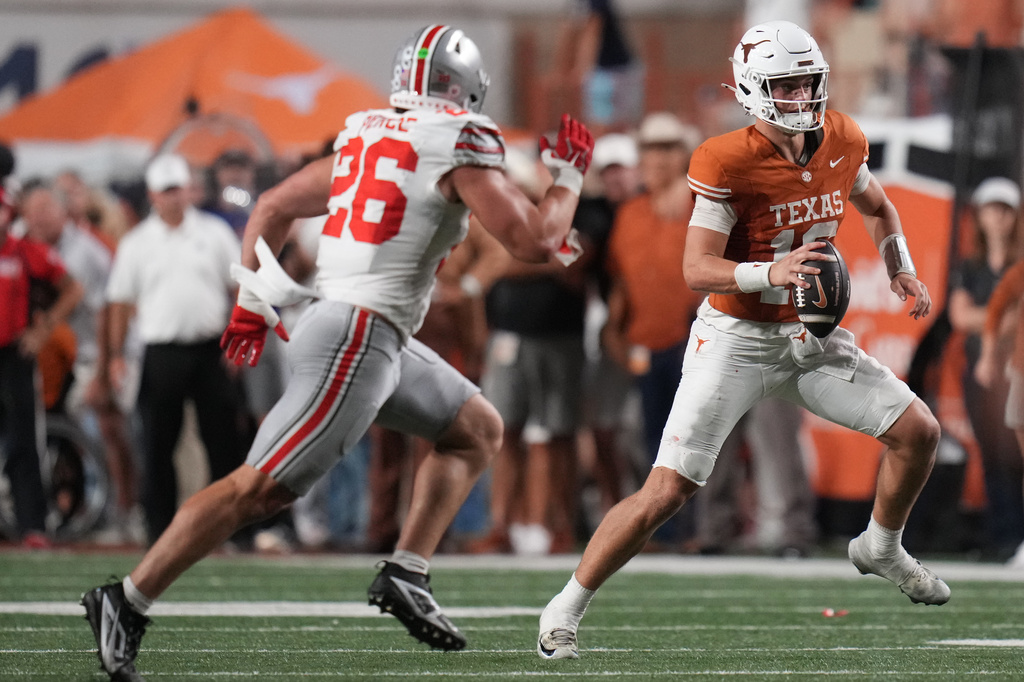 Texas quarterback Arch Manning (16) scramble as Ohio State linebacker Payton Pierce (26) pressured him during the first half of an NCAA college football game in Austin, Texas, Saturday, Sept. 12, 2026. (AP Photo/Eric Gay)