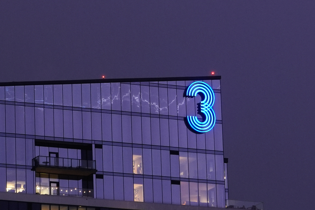 Lightning is reflected in the glass exterior of an apartment building as a thunderstorm moves through the area Thursday, April 23, 2026, in Kansas City, Mo. (AP Photo/Charlie Riedel)